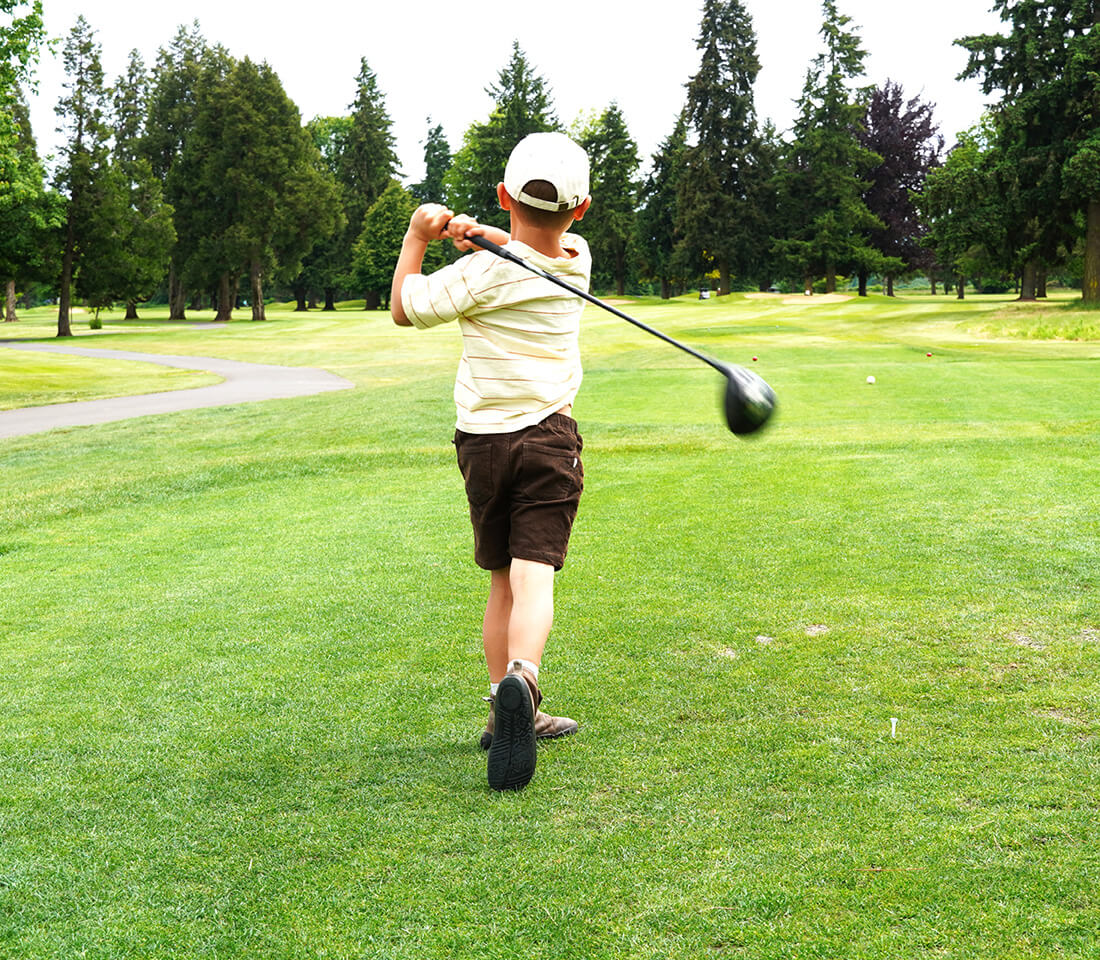 kid swinging golf club